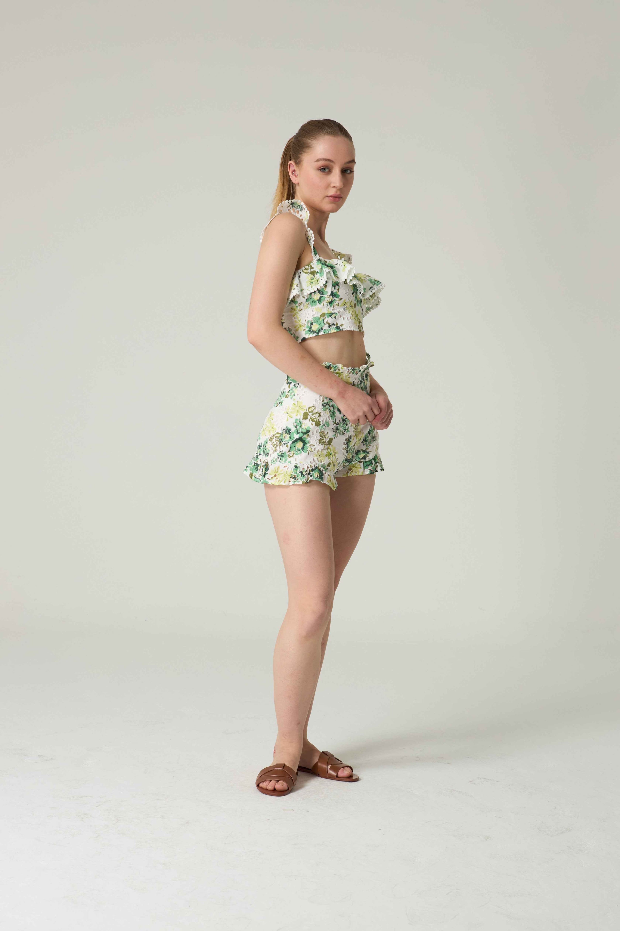 Woman wearing a floral two-piece outfit on a plain background.