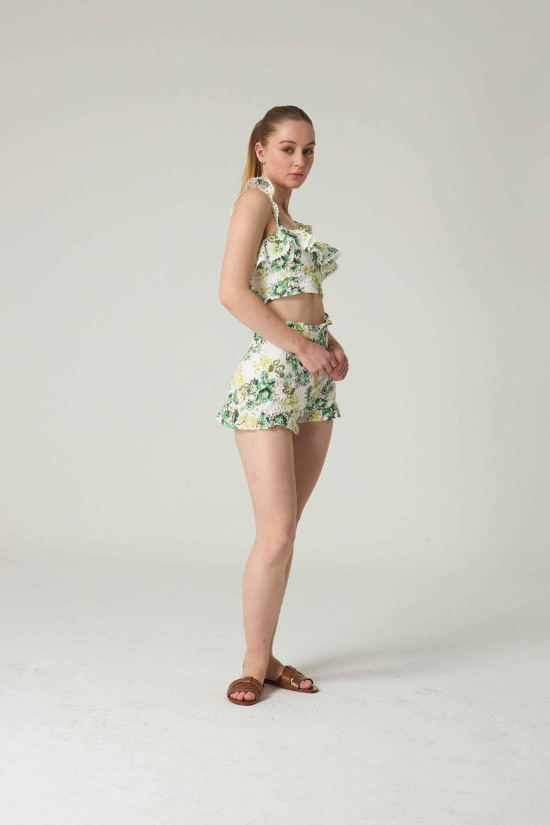 Woman wearing a floral two-piece outfit on a plain background.