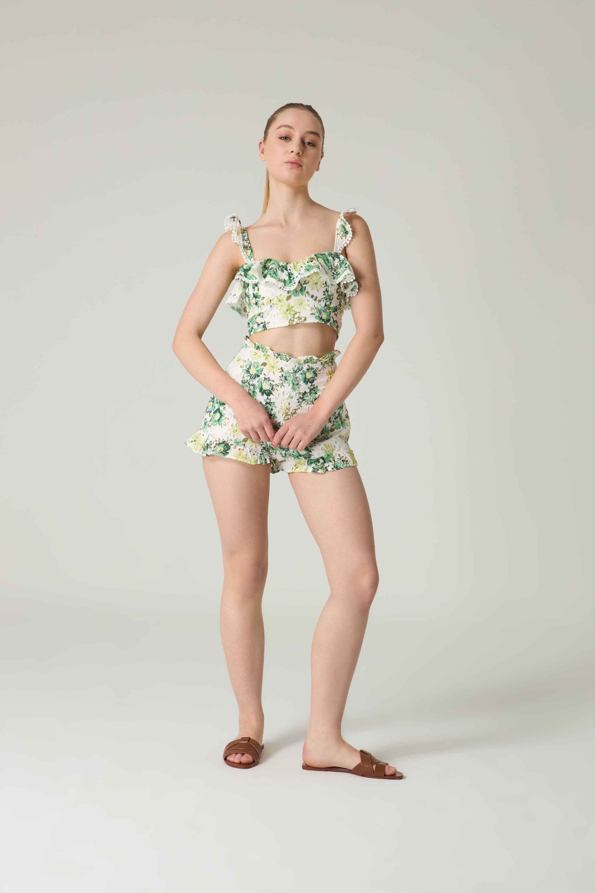 Woman wearing a floral two-piece outfit on a plain background.