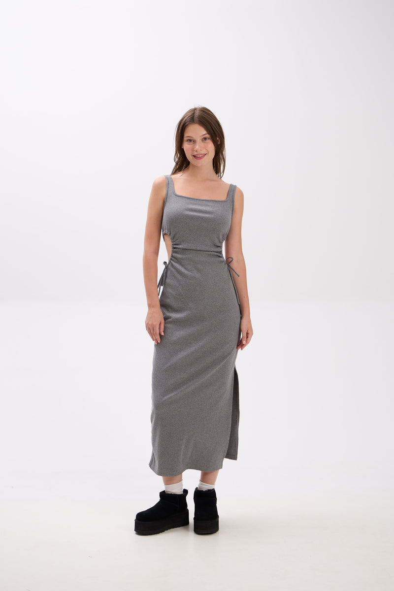 Woman wearing a gray sleeveless dress on a white background.