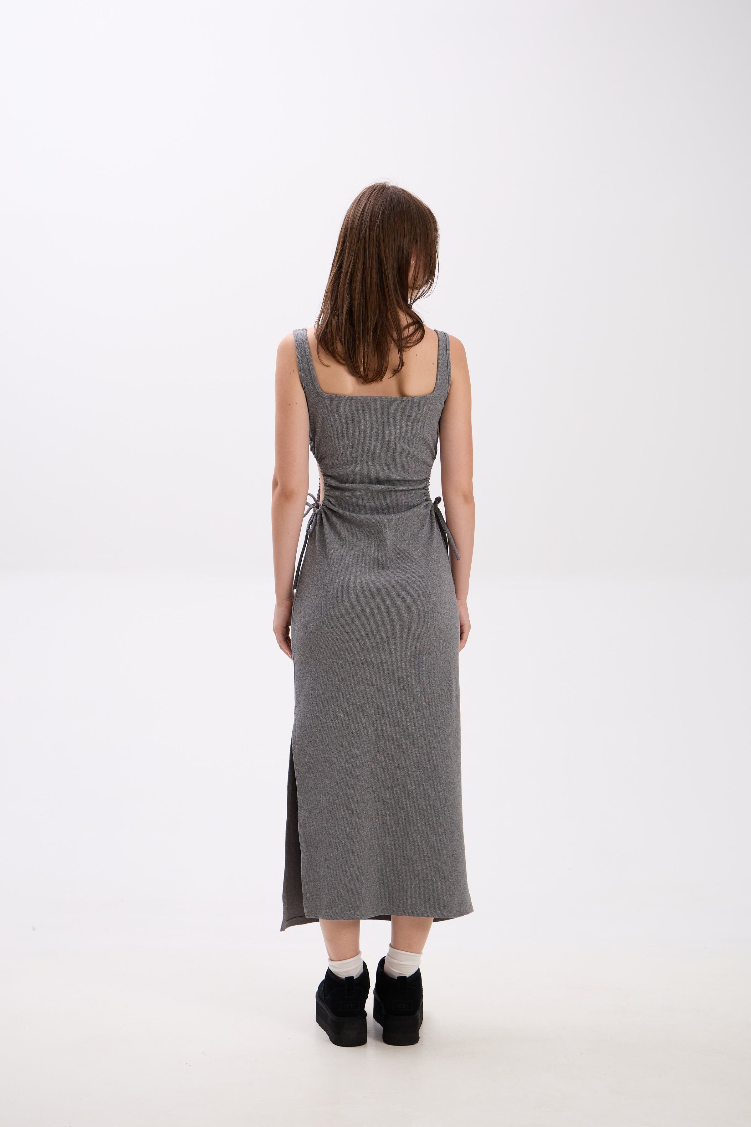 Woman wearing a gray dress on a white background.