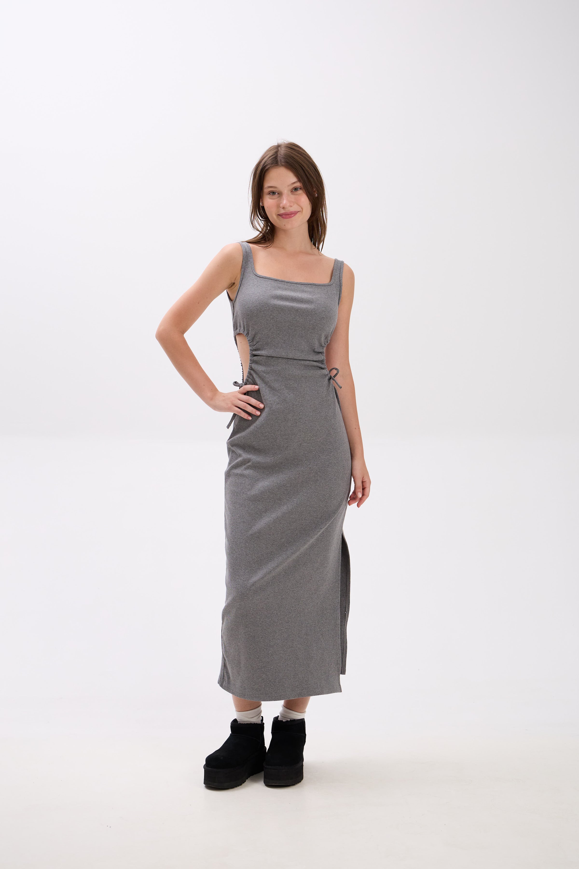 Woman wearing a gray sleeveless dress on a white background.