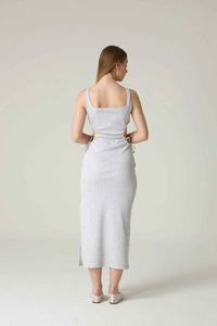 Woman wearing a light gray dress against a plain background.