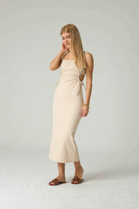 Woman wearing a beige dress on a white background.