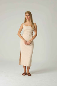 Woman wearing a beige dress on a white background.