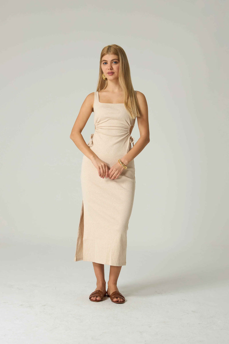 Woman wearing a beige dress on a white background.