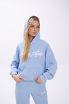 Woman wearing a light blue hoodie with white 'Stay Close' text on a white background.