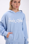 Light blue hoodie with 'Stay Close' text worn by a person on a white background.