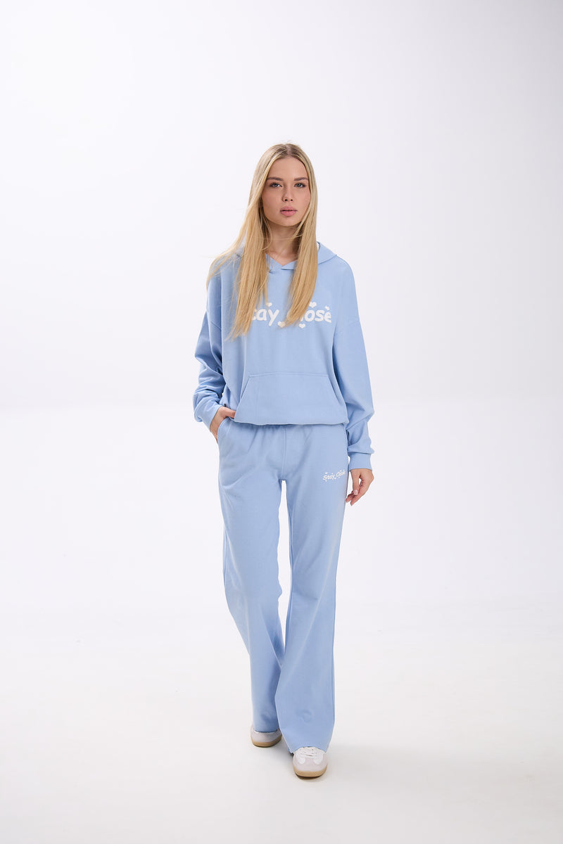 Person wearing a light blue tracksuit with 'Stay Close' text on a white background.