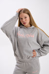 Woman wearing a gray hoodie with pink 'Stay Close' text on a white background.