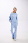Woman wearing a light blue hoodie and sweatpants with 'Stay Close' text on a white background.