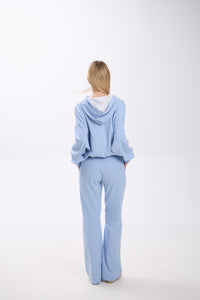 Person wearing a light blue outfit on a white background.