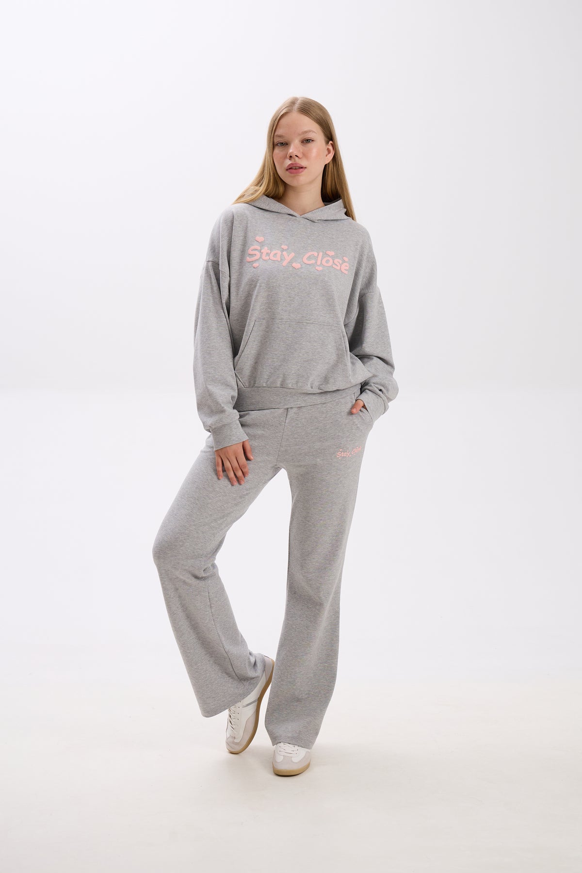 Person wearing a gray hoodie and sweatpants with 'Stay Close' text on a white background.