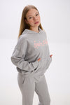 Person wearing a gray hoodie and grey sweatpants with pink text on a white background.