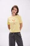 Woman wearing a yellow t-shirt with a graphic design on a white background.