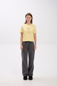 Person wearing a yellow t-shirt and gray pants on a white background.