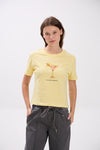 Woman wearing a yellow t-shirt with a graphic design on a white background.