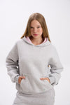 Person wearing a gray hoodie with pink lining on a white background.