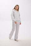 Person wearing a gray tracksuit on a white background.