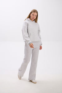 Person wearing a gray tracksuit on a white background.