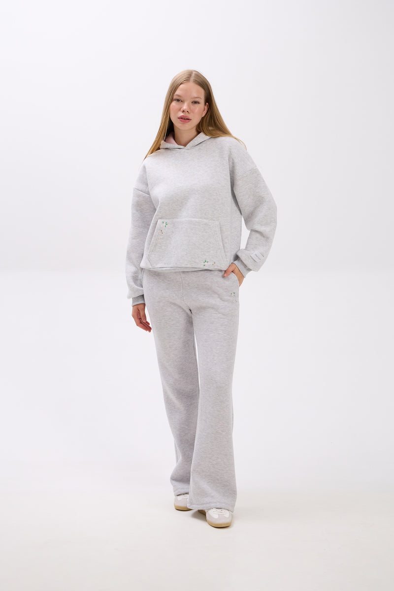 Person wearing a gray tracksuit on a white background.