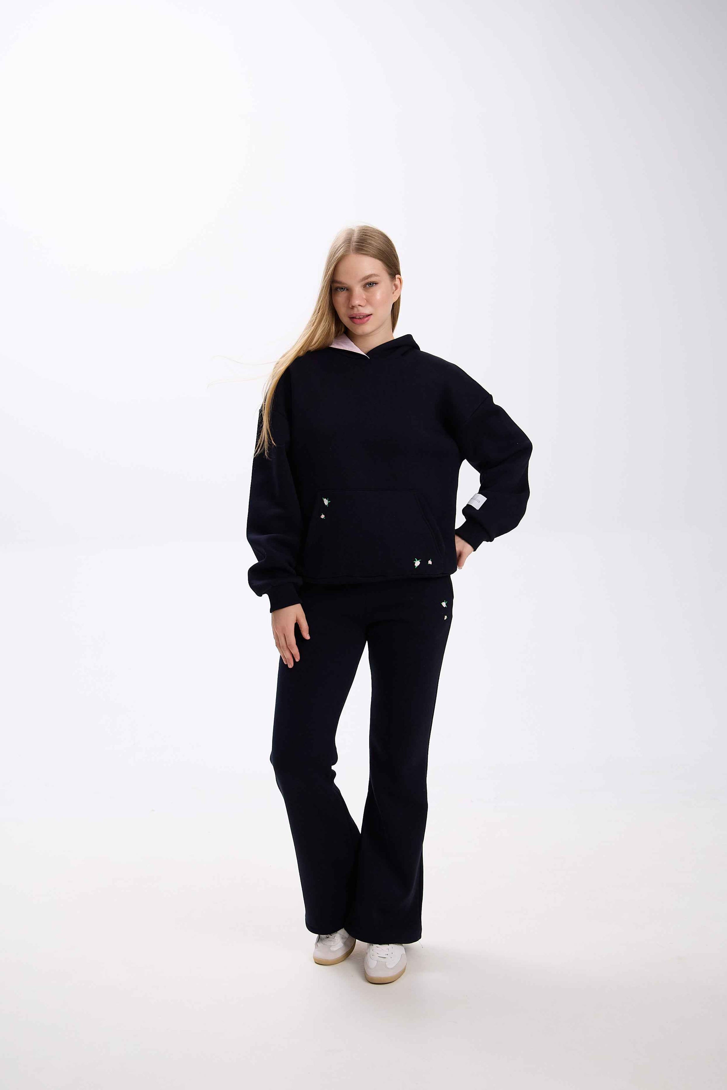 Person wearing a black outfit on a white background.