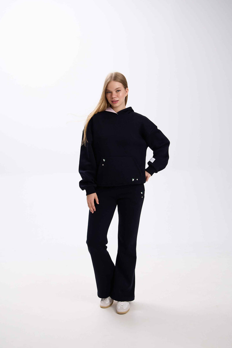 Person wearing a black outfit on a white background.