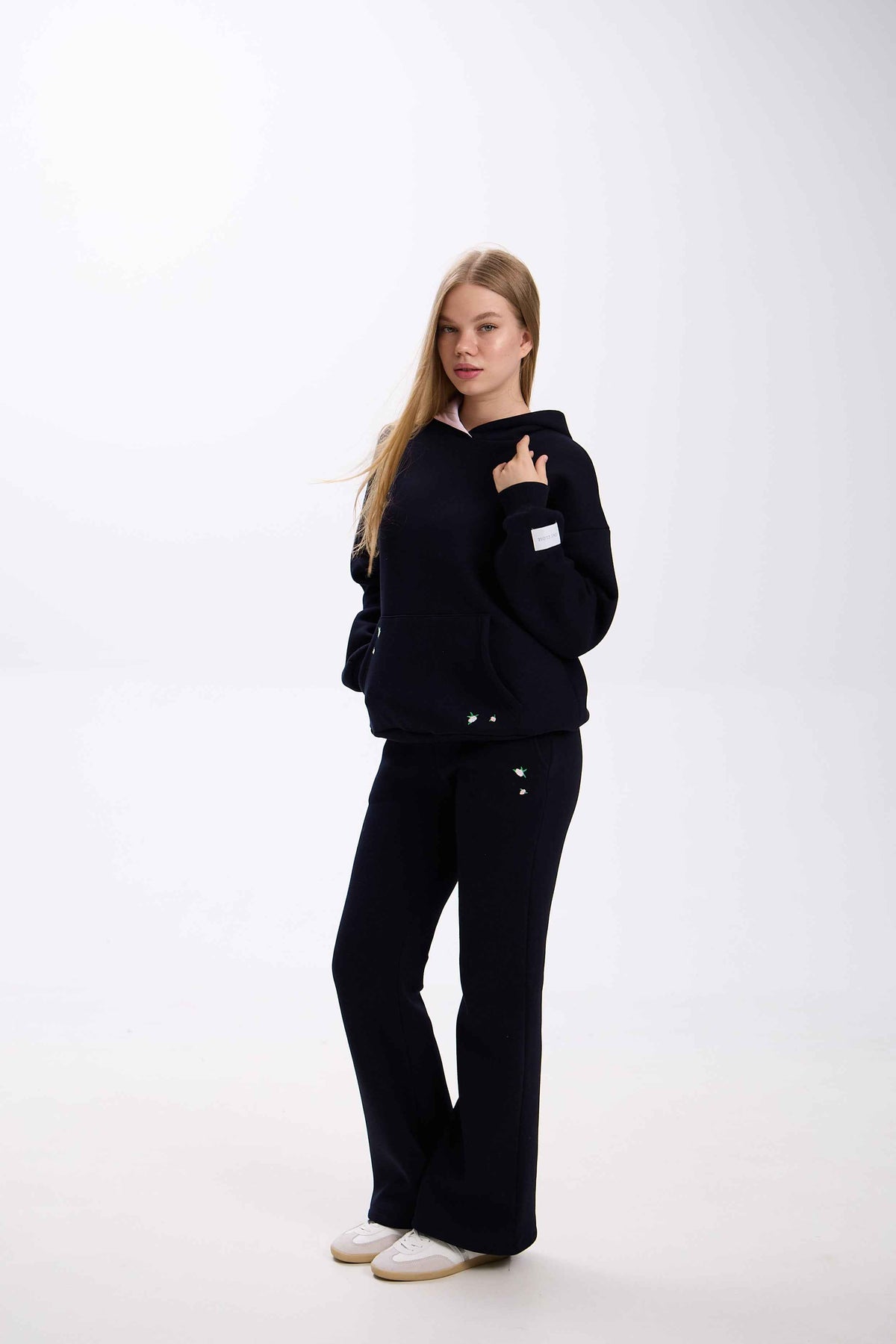 Person wearing a black outfit on a white background.