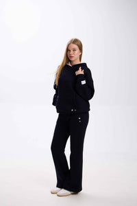 Person wearing a black outfit on a white background.