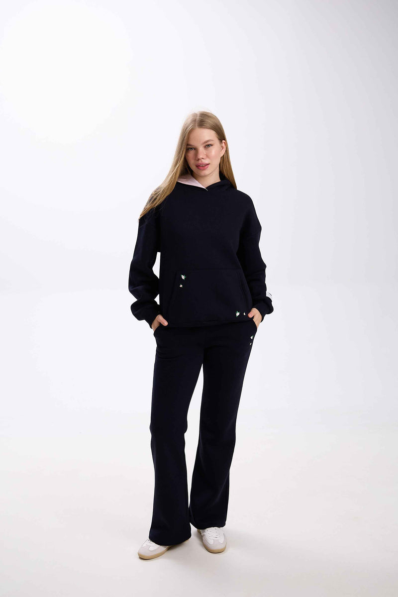 Person wearing a black outfit on a white background.