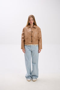 Person wearing a tan jacket and light blue jeans on a white background.