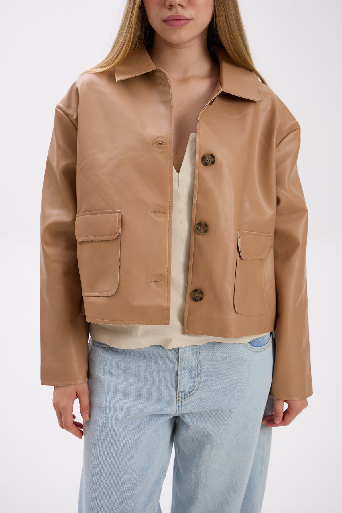 Person wearing a tan leather jacket with a white background.