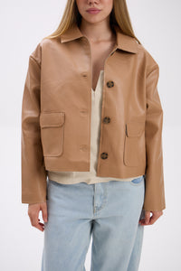 Person wearing a tan leather jacket with a white background.
