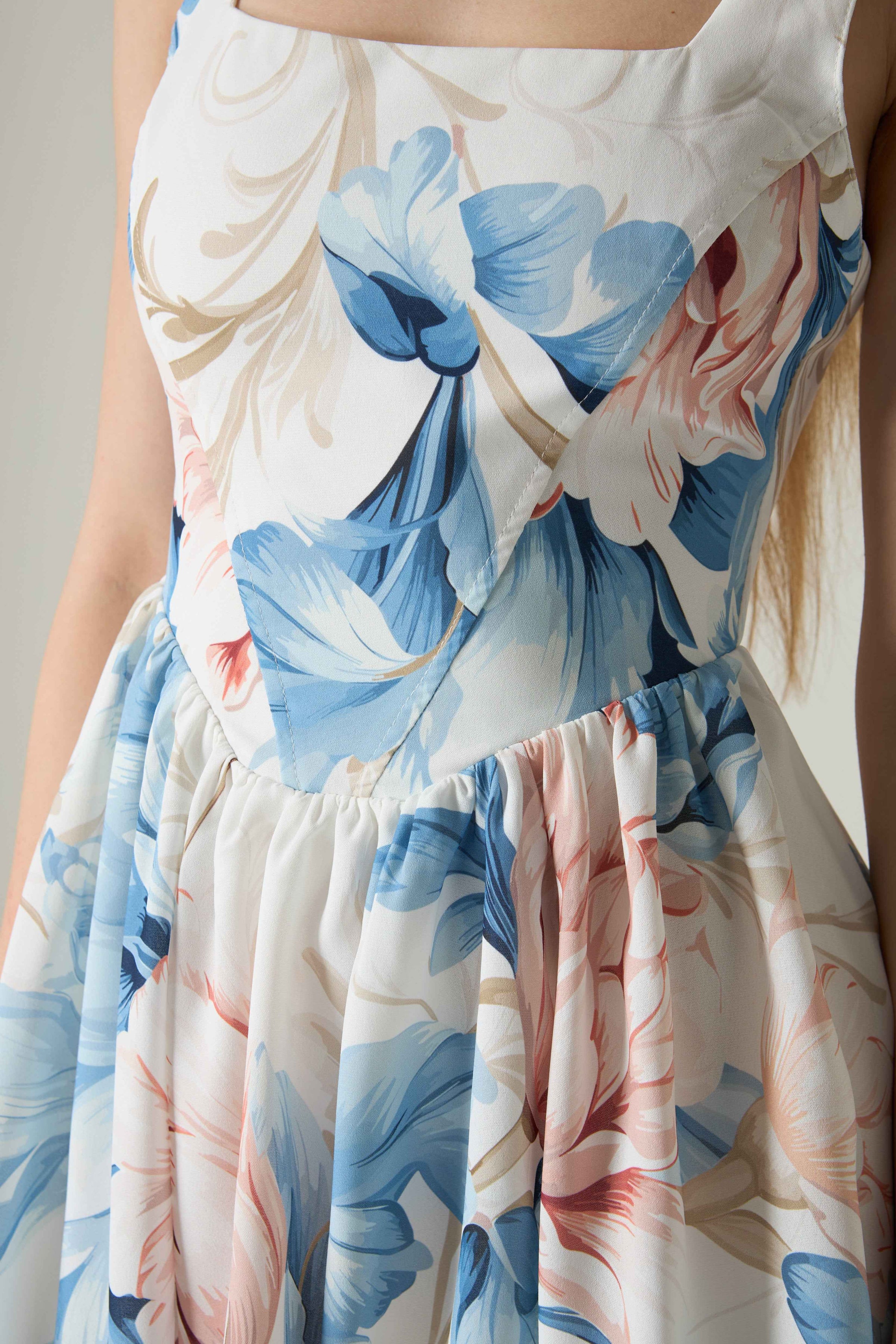 Floral dress with blue and pink flowers on a neutral background.