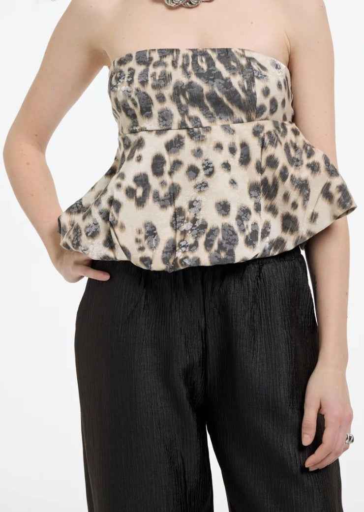 Leopard print peplum top worn by a person on a white background.