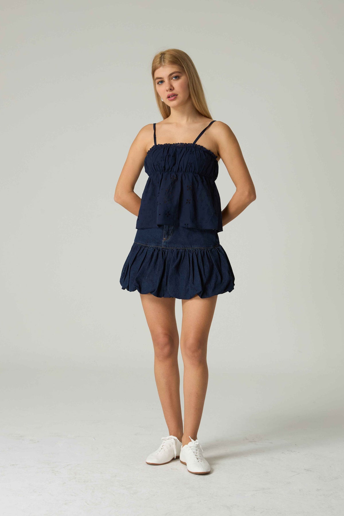 Woman wearing a navy blue dress on a white background.