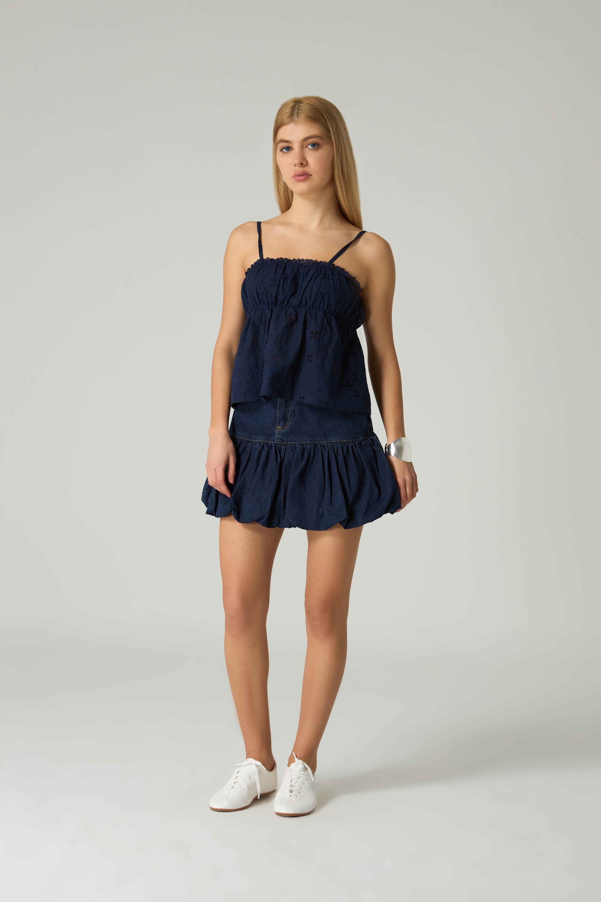 Woman wearing a navy blue dress on a white background.