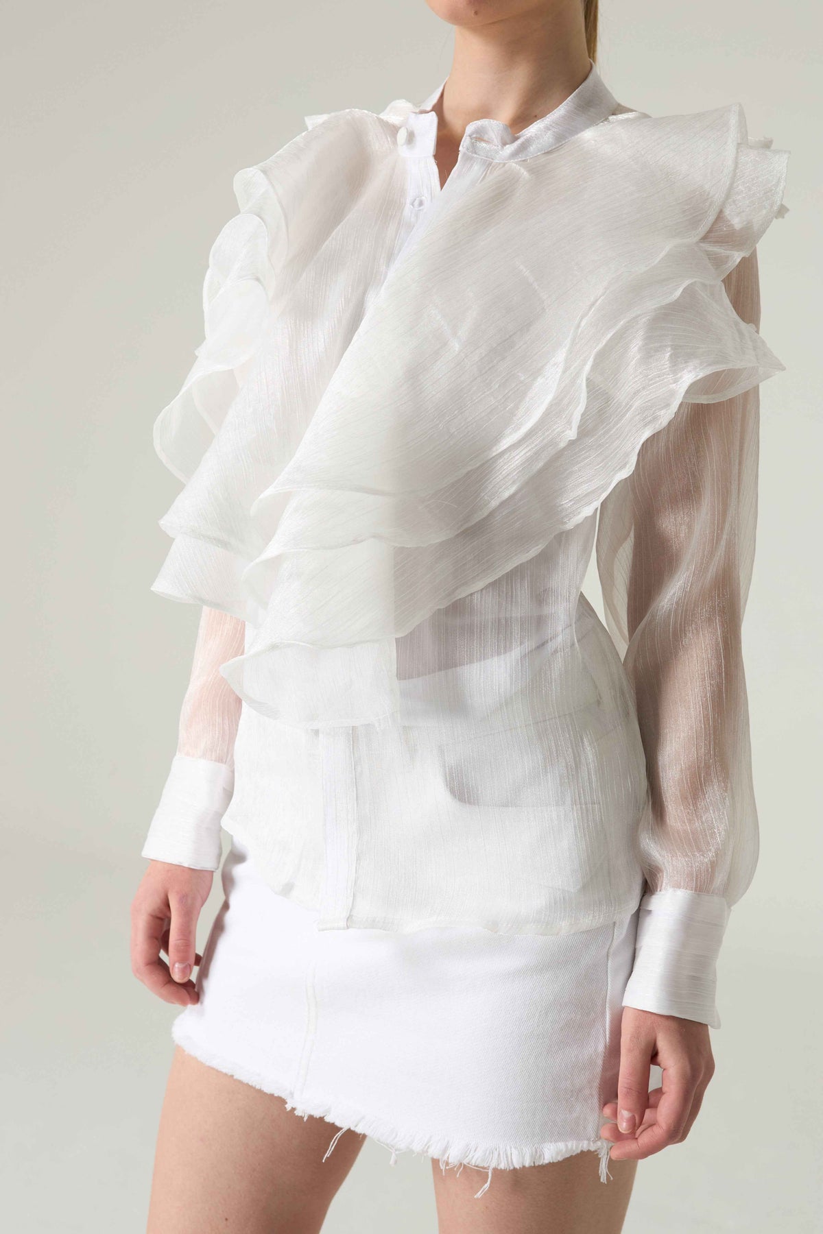 White ruffled blouse and skirt set on a plain background.