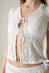 White textured top with lace-up front on a neutral background.