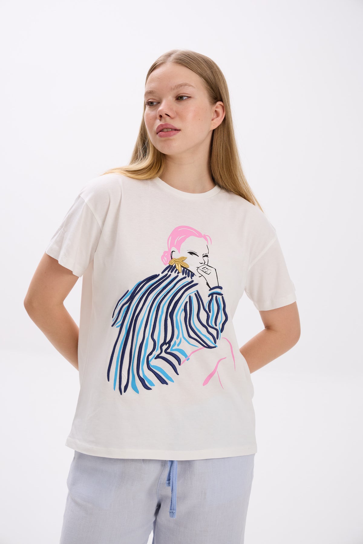 Person wearing a white t-shirt with a colorful graphic design on a white background.