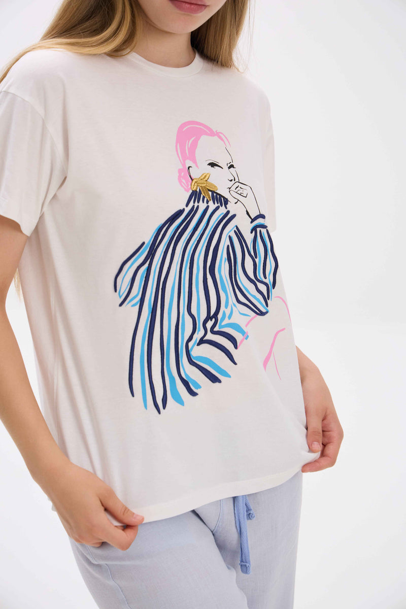 Person wearing a white t-shirt with a colorful zebra design on a plain background.