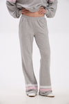 Person wearing gray sweatpants with pink accents on a white background.