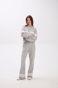 Person wearing a gray tracksuit with pink accents on a white background.