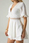 White dress with lace details on a plain background.