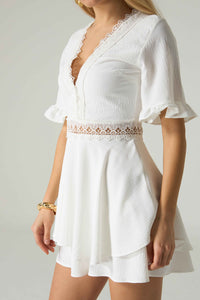 White dress with lace details on a plain background.