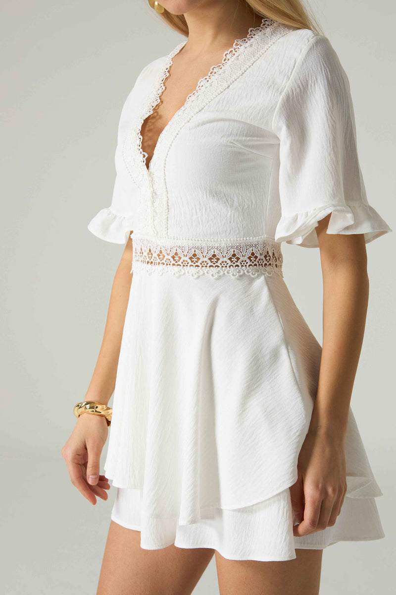 White dress with lace details on a plain background.