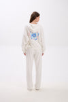 Person wearing a white hoodie with a blue butterfly design on a white background.
