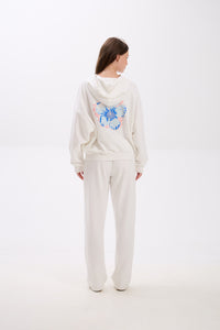 Person wearing a white hoodie with a blue butterfly design on a white background.