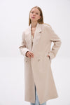Woman wearing a beige coat on a white background