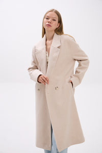 Woman wearing a beige coat on a white background